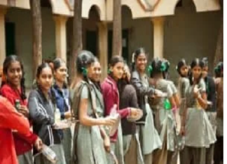 Middle Class People Lifestyle and Problems A group of middle school students in uniform stands in a line outdoors, holding items in their hands, with trees and a building in the background.