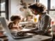 A woman works on a laptop at a desk, exploring the best side hustles for working moms, while a child draws beside her in the sunlit room.