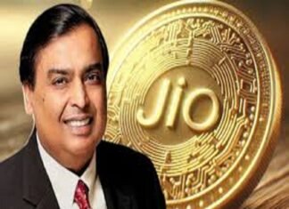 A smiling man in a suit stands proudly in front of a large Jio Coin, its embossed, circuit-like design gleaming with innovation.